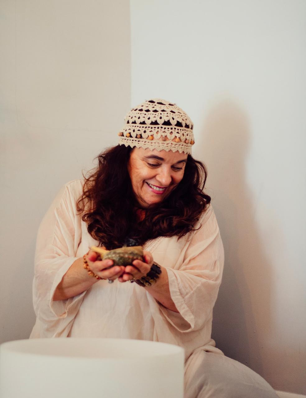 Claudia Cuencos smiling indoors, with a white crystal bowl in the foreground